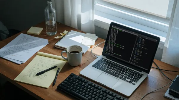 Laptop on a desk showing a Python terminal with import timing output, coffee mug, no readable secrets