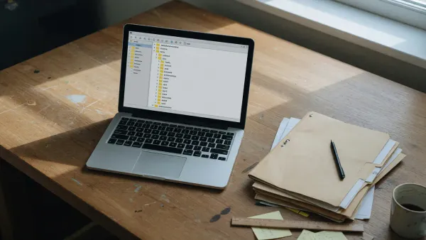 A laptop on a desk showing a simple folder tree of year and month parquet files, a coffee mug beside it, daylight, no logos