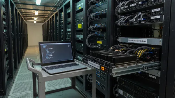 Server rack aisle with a laptop showing a YAML file next to a labeled GPU sled, cool warehouse light, no logos